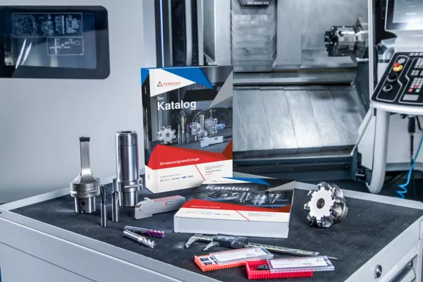 Das Bild zeigt den Produktkatalog der Ceratizit Group in gebundener Form, präsentiert mit einigen Werkzeugteilen des Unternehmens auf einem Arbeitsplatz. 